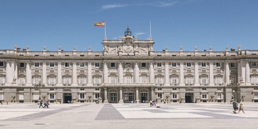 3/3ChatGPT A grand view of the Royal Palace in Madrid, showcasing its stately Baroque architecture with ornate facades, large arched windows, and grandiose entrance. 