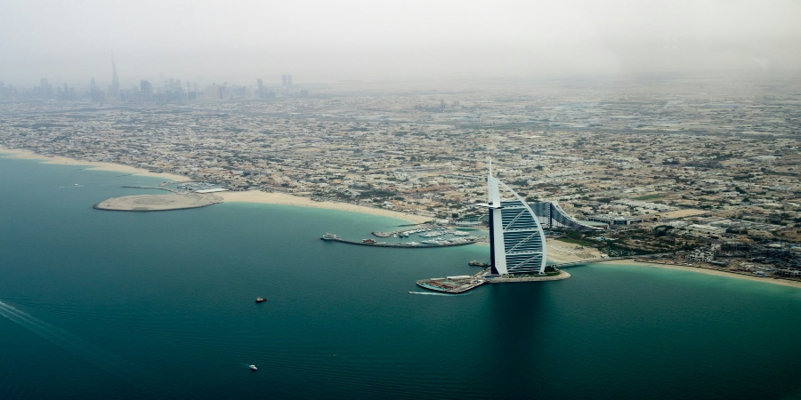 A breathtaking distant view of the iconic Burj Al Arab, its sail-shaped silhouette standing elegantly against the Dubai skyline.