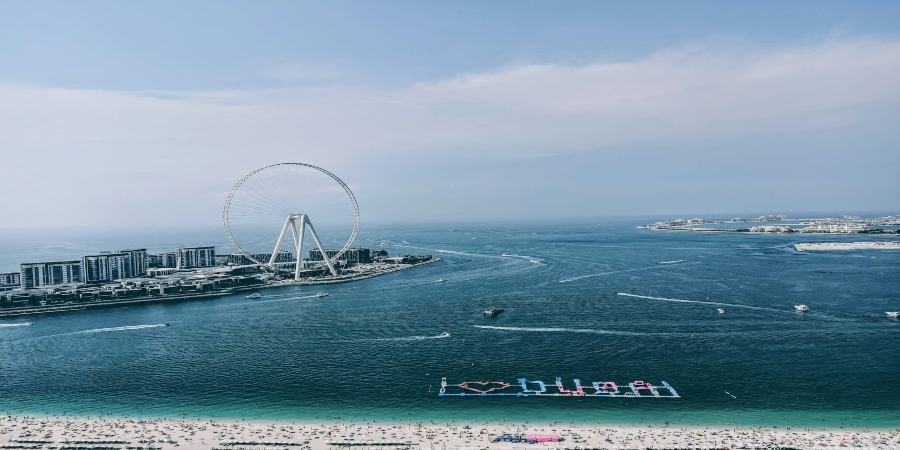 A stunning distant view of JBR Dubai, showcasing its vibrant beachfront, high-rise buildings, and lively atmosphere along the coast.