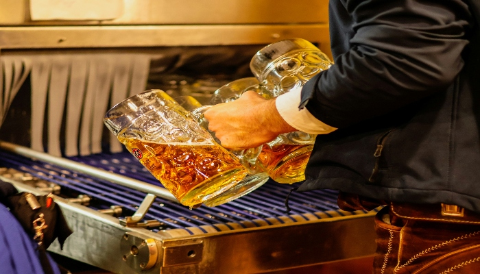 A person refilling big glasses of beer
