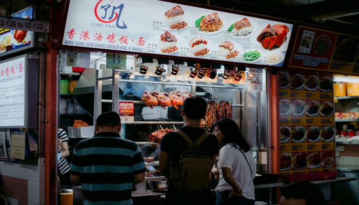 People queuing at a popular Singapore hawker center food stall, one of the authentic cultural stops during Singapore city tours.