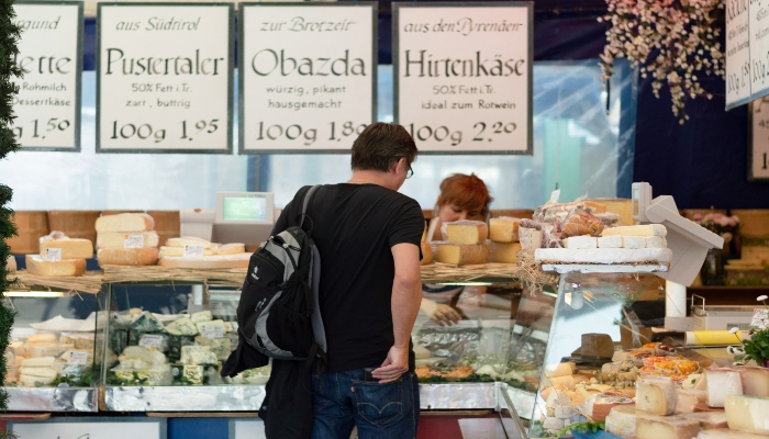 Traveler picking cheeses at Viktualienmarkt, a must-do food experience for your Munich in one day itinerary.