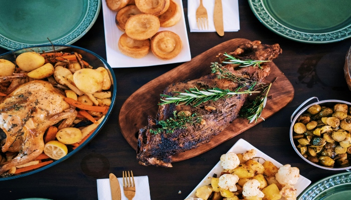 Traditional roast meats, potatoes, and vegetables fill a holiday table, featuring authentic festive cuisine from christmas holiday destinations europe.