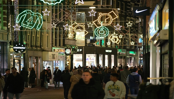 Busy shopping street decorated with Christmas lights and crowds, showcasing the lively atmosphere of Europe’s top festive markets.