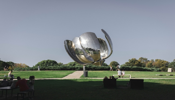 Modern sculpture Floralis Genérica in a green Buenos Aires park under a clear sky, a popular stop for many Buenos Aires tourist bus sightseeing routes.