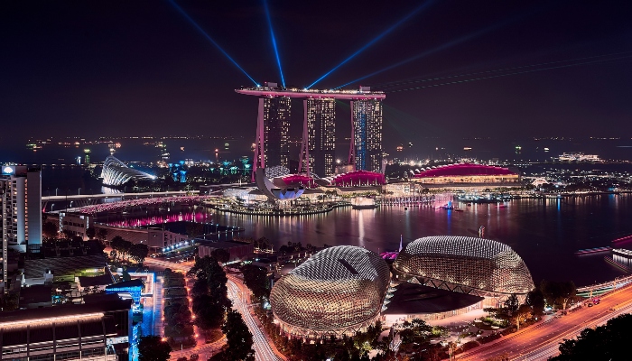 Night view of Marina Bay Sands and Esplanade domes lit up over the bay, showcasing landmarks featured in a Singapore sightseeing bus comparison guide.