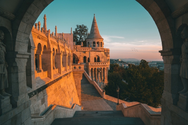 Fisherman’s Bastion in the Buda Castle District at sunset, featured on Budapest sightseeing bus routes.