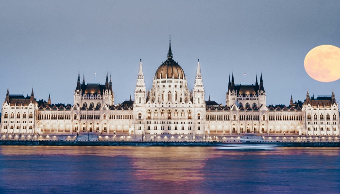 Hungarian Parliament illuminated at night across the Danube, part of is hop-on hop-off worth it Budapest experience.