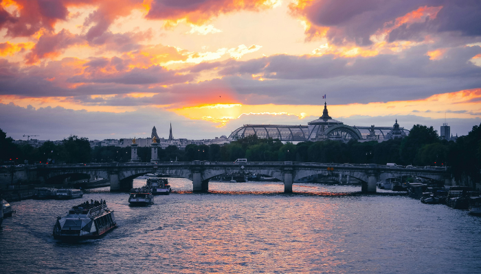 Sunset view over the River Seine with boats and historic bridges, a romantic Valentine’s Day in Paris evening atmosphere.
