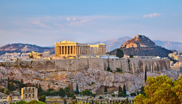 Panoramic view of the Acropolis and Parthenon in Athens at sunset from city viewpoint.