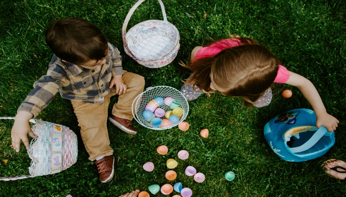 Children enjoying an Easter egg hunt outdoors, symbolizing family-friendly Easter travel.