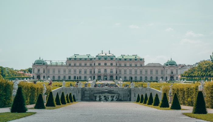 Front view of Belvedere Palace in Vienna with symmetrical gardens and fountains on a bright day.