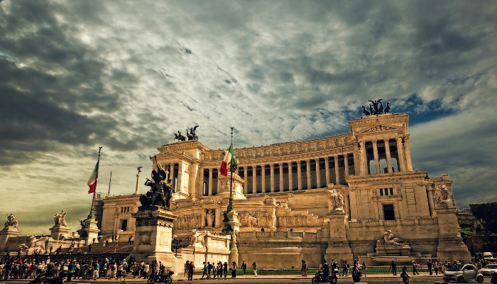 Altare della Patria in Rome with Italian flags and crowds during the Easter holiday season.