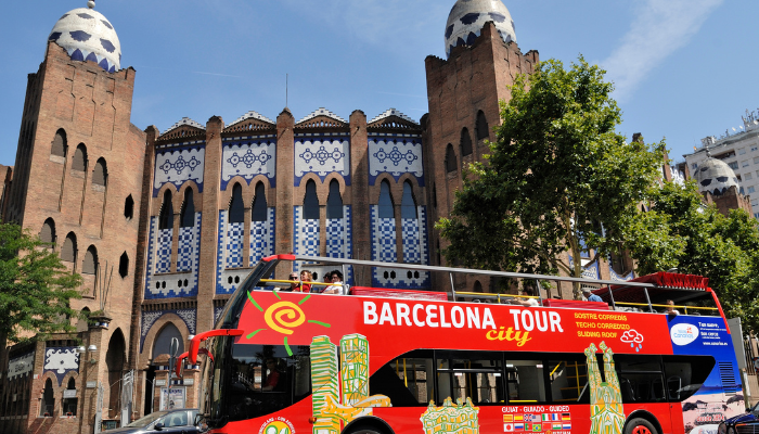 Barcelona hop-on hop-off sightseeing bus passing historic buildings during city tour.