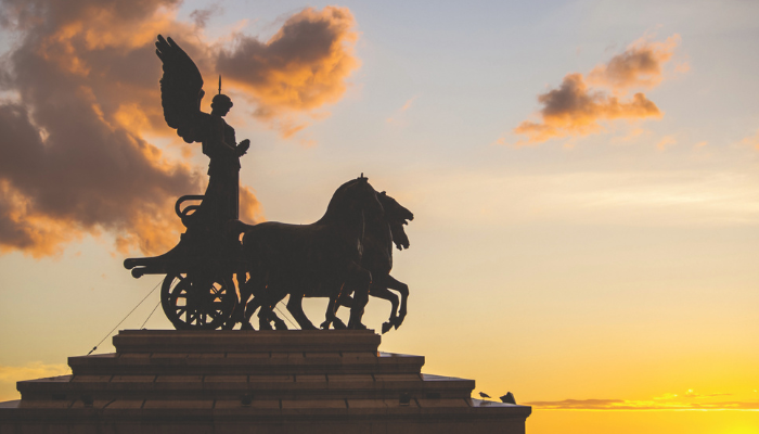 Quadriga statue on top of Brandenburg Gate in Berlin during a golden spring sunset.