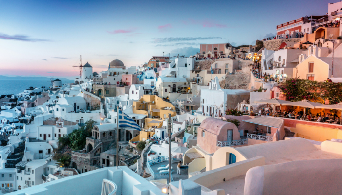 Whitewashed buildings and blue-domed churches on Santorini’s caldera cliffs above the Aegean Sea, one of the best beach holiday destinations in Europe.