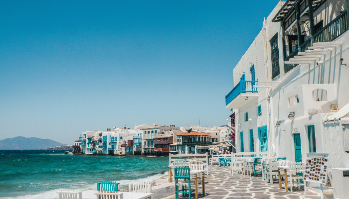Seaside cafés and whitewashed houses along the Mykonos waterfront in the Greek Islands.