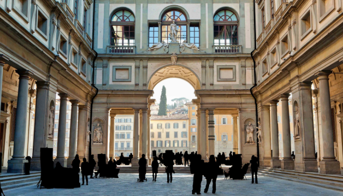Visitors walking through Uffizi Gallery corridor in Florence, Renaissance art stop on a Florence one day itinerary.