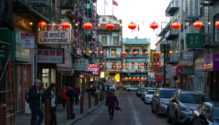 Lantern-lined street in San Francisco Chinatown with shops and pedestrians exploring the historic district.