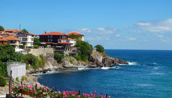 Coastal village in Bulgaria with red-roof houses, rocky shoreline, and Black Sea view.