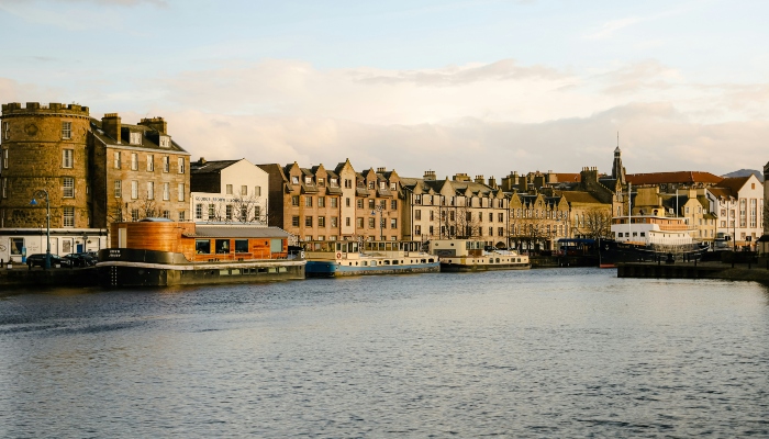 Scenic waterfront view of Leith harbor with historic buildings along Edinburgh’s shoreline.
