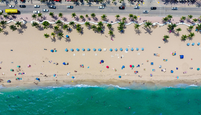 Aerial view of Fort Lauderdale beach with palm-lined shores and turquoise water, a popular LGBTQ-friendly beach destination.