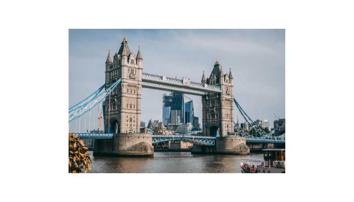 Tower Bridge in London viewed from the riverside on a bright day with boats on the Thames.