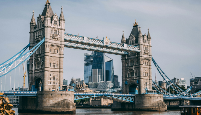Tower Bridge in London viewed from the riverside on a bright day with boats on the Thames.