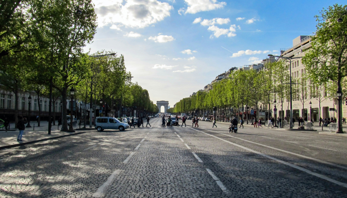 Wide view of Champs-Élysées in Paris leading toward the Arc de Triomphe, a popular sightseeing route for visitors.