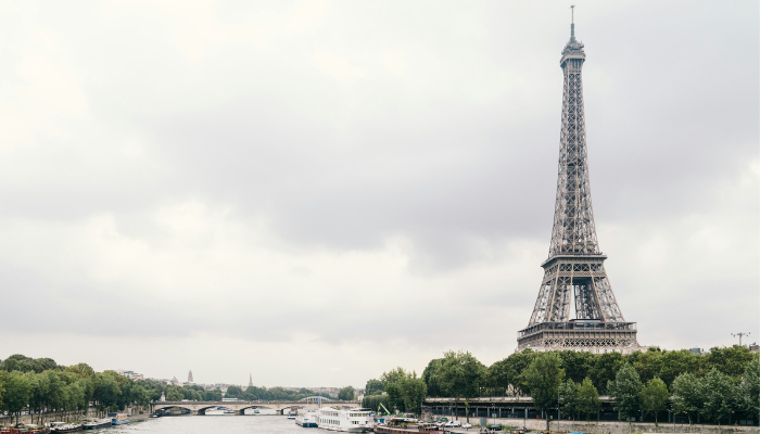 Scenic daytime view of the Eiffel Tower beside the Seine River in Paris, a famous landmark often visited on sightseeing tours.