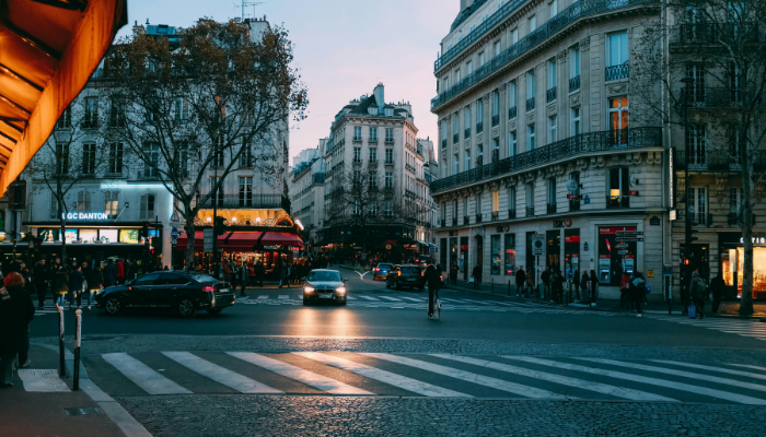 Evening street view in Paris with cafés, traffic, and city lights, showing the atmosphere of exploring Paris after sunset.