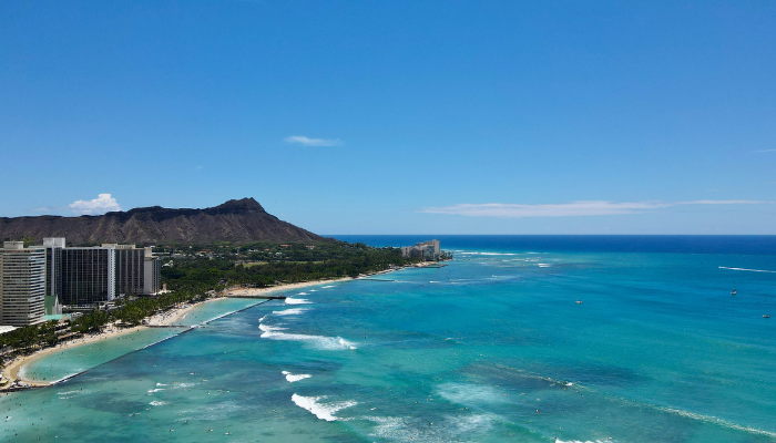 Panoramic view of Waikiki Beach and Honolulu coastline with turquoise waters and mountain scenery in Hawaii.