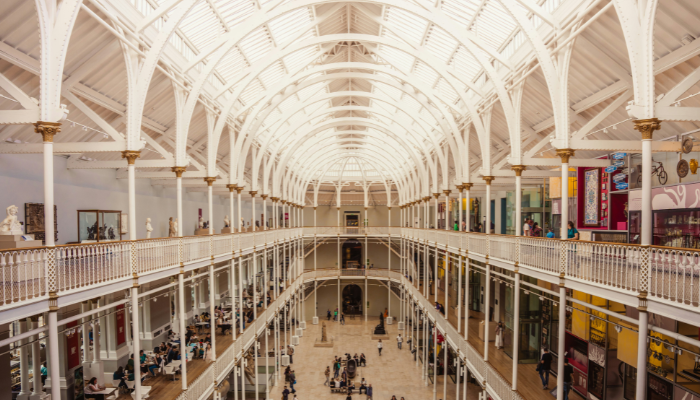 Grand interior hall of the National Museum of Scotland showcasing Victorian architecture and exhibition galleries in Edinburgh.