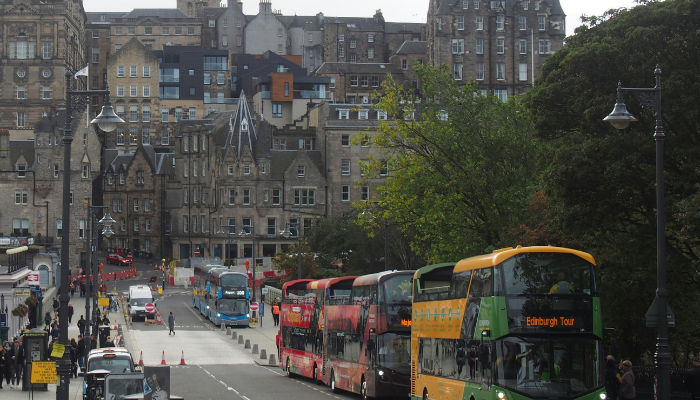 Hop-on hop-off Edinburgh buses lined up near the city centre, offering a convenient way to explore major attractions.