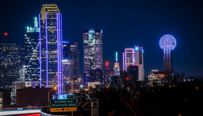 Dallas skyline glowing at night with illuminated skyscrapers and city lights in downtown Dallas