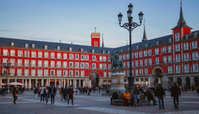 Historic Plaza Mayor square surrounded by red arcaded buildings in Madrid.