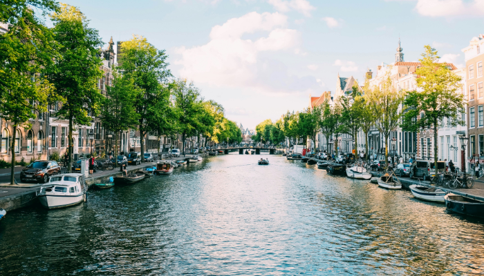Canal lined with historic houses and boats in Amsterdam, one of the best cities for solo travel in Europe.