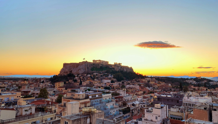 Sunset view of the Acropolis above Athens, highlighting the city's historic skyline after a day of sightseeing by hop-on hop-off bus.