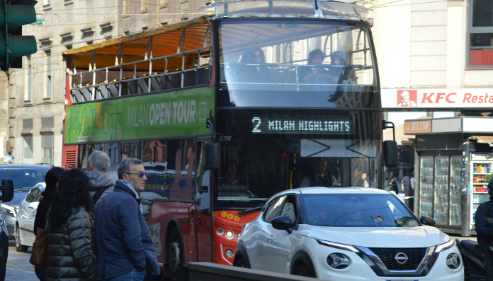 A Milan Open Tour hop-on hop-off bus travelling through central Milan on the Milan Highlights route.