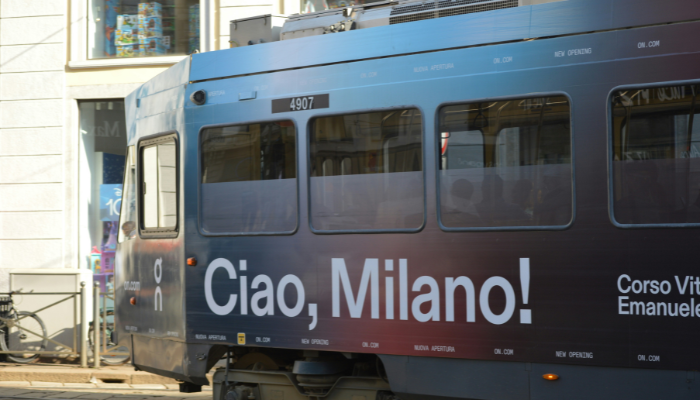 The iconic 'Ciao, Milano!' tram passing through the city centre, showcasing Milan's historic public transport and vibrant streets.
