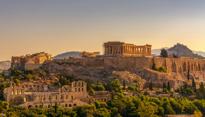Acropolis of Athens overlooking the ancient city and surrounding hills at sunset.