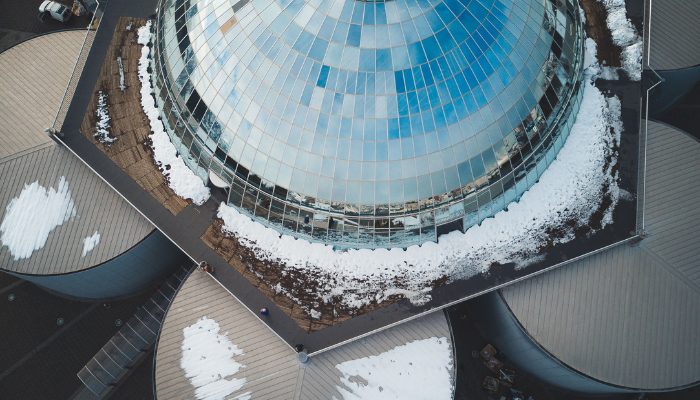Aerial view of Perlan’s glass-domed building surrounded by snow in Reykjavik