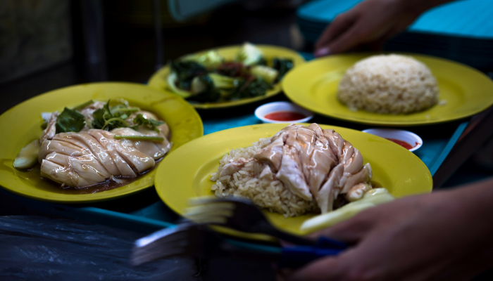 Plates of Hainanese chicken rice and other dishes served at a Singapore hawker centre.