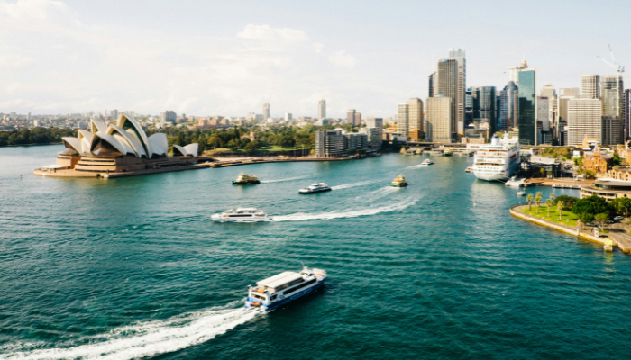 Aerial view of Sydney Harbour featuring the Sydney Opera House, ferries and the city skyline along the sightseeing bus route.
