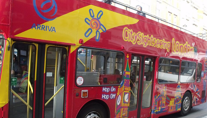 City Sightseeing London red double-decker hop-on hop-off bus on a city street.