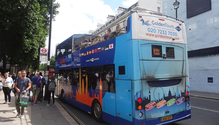 Golden Tours open-top sightseeing bus stopped on a London street.