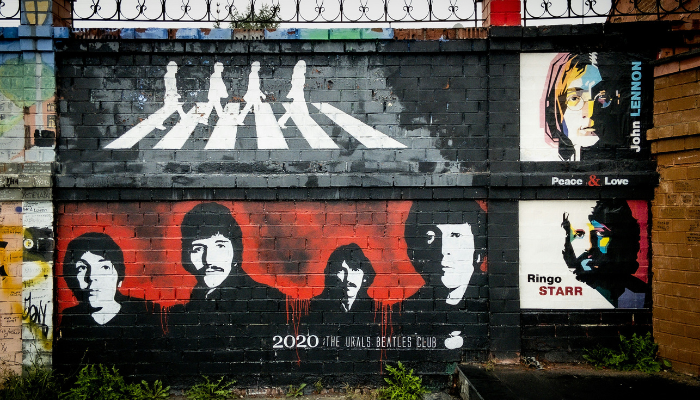 Beatles mural featuring portraits of the four members on a wall in Liverpool.