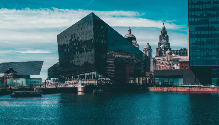 Liverpool waterfront with the Museum of Liverpool and Royal Liver Building under a blue sky.