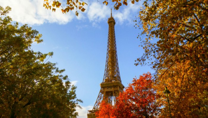 Autumn view of the Eiffel Tower in Paris surrounded by trees with golden and orange leaves