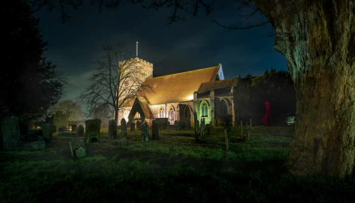 Edinburgh church and graveyard at night with a mysterious figure in the distance